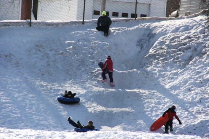 Tubing on hill above Monroe Street skating rink in 2021