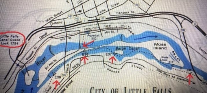 The 4 short Red Arrows show the Locations of the 1825 Erie Canal Locks | E36 : Lock 36, known as the Mile Lock, which had a mule shed, where mules could be rented; E37 : Lock 37, which was known as the Van Allen’s Lock, which was a mechanics drydock that was used for boat repairs; E38 : Lock 38, which was known as Perry’s Lock: and E39 : Lock 39, which was known as Leigh’s Lock. | The route of the 1825 Erie Canal is shown on the map with a dotted line on the south side of the Loomis, Seeley and Moss Island | Also marked on the map is a longer Red Arrow marking the location of the 1822 Aqueduct | Circled in Red is the 1795 Guard Lock of the Western Inland Lock Navigation Canal, with the canal path shown on the map with Black Dots, that also includes the 5 lift locks, shown with the symbol of
