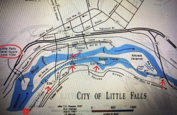 The 4 short Red Arrows show the Locations of the 1825 Erie Canal Locks | E36 : Lock 36, known as the Mile Lock, which had a mule shed, where mules could be rented; E37 : Lock 37, which was known as the Van Allen’s Lock, which was a mechanics drydock that was used for boat repairs; E38 : Lock 38, which was known as Perry’s Lock: and E39 : Lock 39, which was known as Leigh’s Lock. | The route of the 1825 Erie Canal is shown on the map with a dotted line on the south side of the Loomis, Seeley and Moss Island | Also marked on the map is a longer Red Arrow marking the location of the 1822 Aqueduct | Circled in Red is the 1795 Guard Lock of the Western Inland Lock Navigation Canal, with the canal path shown on the map with Black Dots, that also includes the 5 lift locks, shown with the symbol of