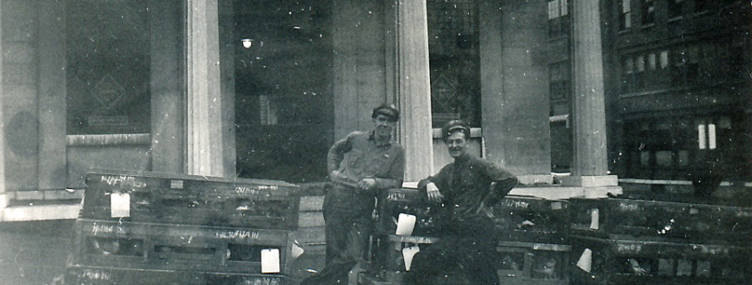 Railway Express Agency employees Al Munger (on left - Al later became Little Falls fire chief) and Jimmy Fitzgerald (on right) pictured with cages of homing pigeons outside of the company office once housed in the Old Bank Building.